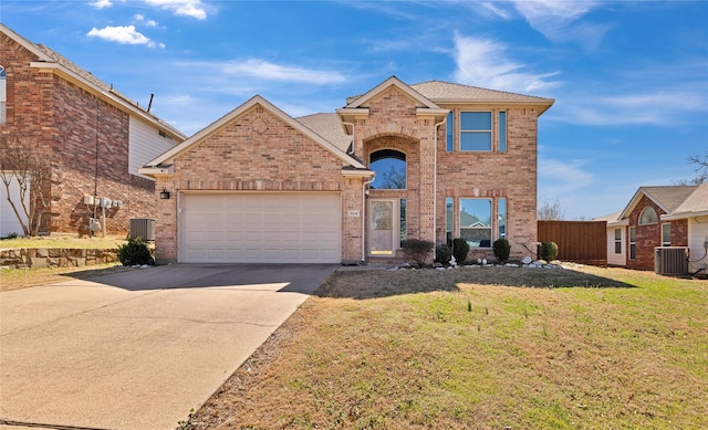 traditional home featuring brick siding, concrete driveway, an attached garage, a front yard, and cooling unit