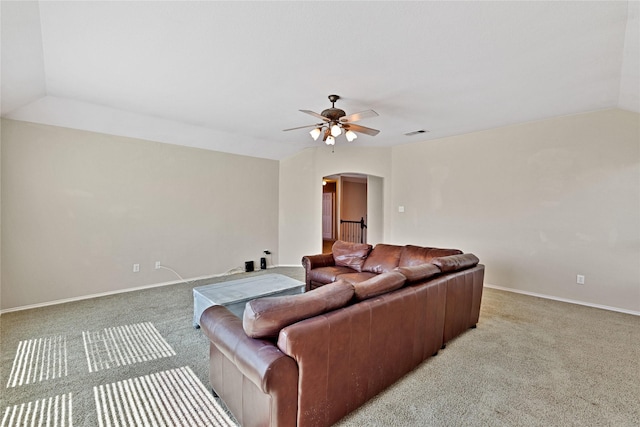 living room featuring arched walkways, ceiling fan, lofted ceiling, light colored carpet, and visible vents