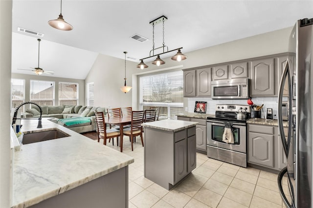 kitchen featuring appliances with stainless steel finishes, gray cabinets, a sink, and visible vents