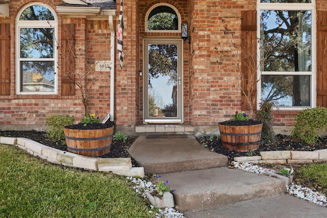 entrance to property featuring brick siding