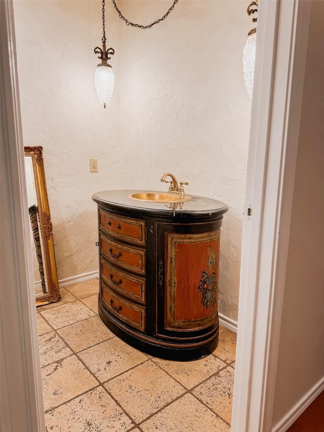 details with vanity, baseboards, and a textured wall