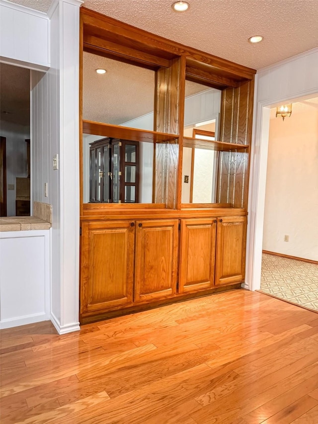 unfurnished room featuring light wood-type flooring, a textured ceiling, and recessed lighting