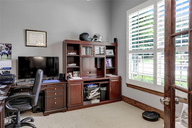 home office featuring light carpet and baseboards