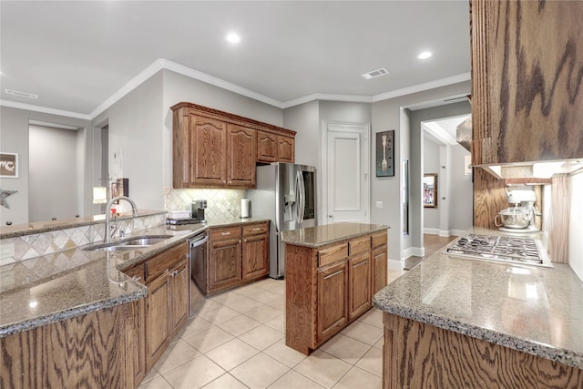 kitchen with stainless steel appliances, stone countertops, visible vents, and a sink