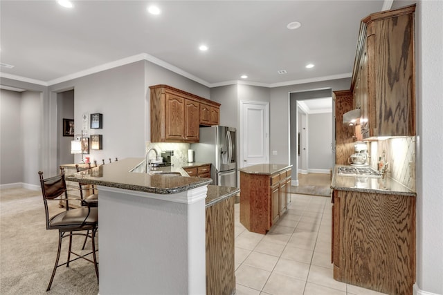 kitchen with a center island, light tile patterned floors, stainless steel appliances, backsplash, and a sink