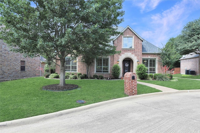 2104 Germantown, Mckinney, TX 75070 - tudor house featuring brick siding, central AC unit, roof with shingles, and a front yard