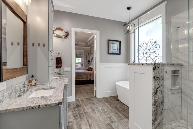 full bathroom featuring wainscoting, wood finished floors, ensuite bathroom, a tile shower, and vanity