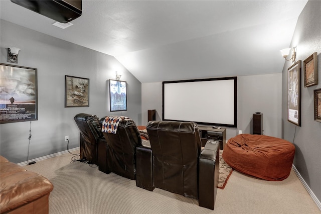 carpeted home theater room with vaulted ceiling and baseboards