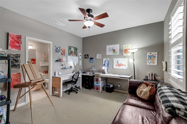 office space featuring light carpet, ceiling fan, and visible vents