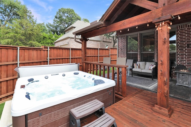 deck with a hot tub, fence, and outdoor lounge area