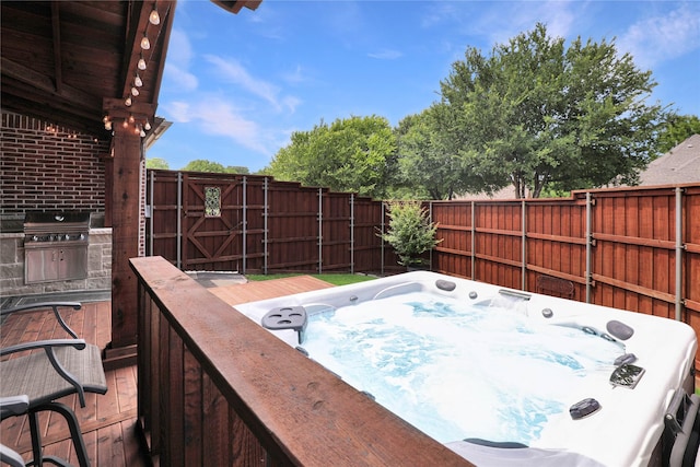 view of patio with a hot tub, a grill, a deck, and a fenced backyard