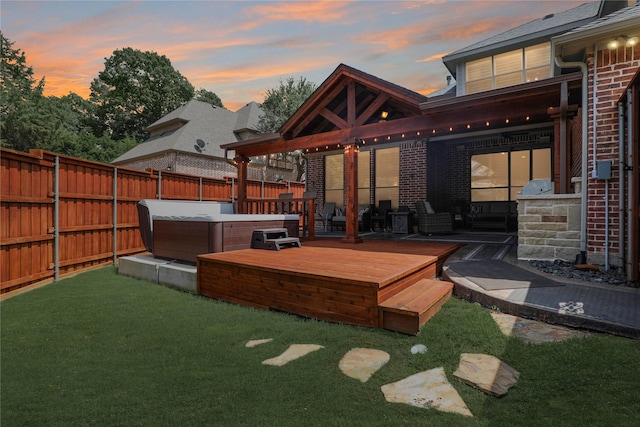 view of yard with a hot tub, a fenced backyard, and a wooden deck