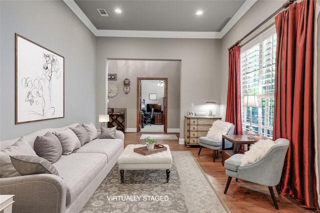 living area featuring baseboards, visible vents, ornamental molding, wood finished floors, and recessed lighting