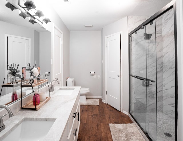 full bath featuring a stall shower, a sink, and toilet