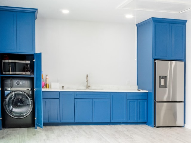 laundry room with light wood-style flooring, laundry area, a sink, attic access, and washer / dryer