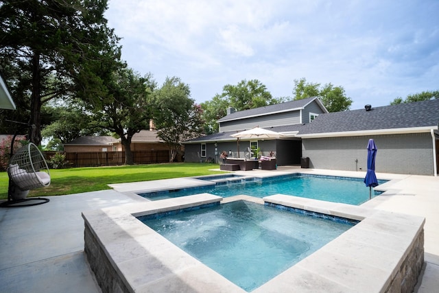 view of pool with a pool with connected hot tub, fence, a lawn, and a patio