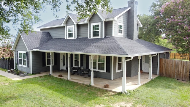 view of front of property with a shingled roof, a chimney, fence, and a front yard