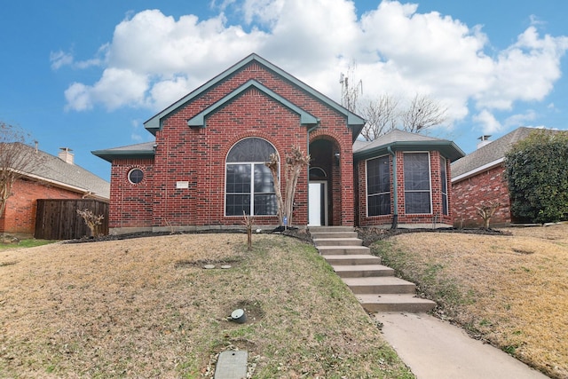 view of front of home featuring brick siding and a front lawn