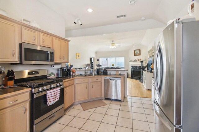 kitchen featuring stainless steel appliances, visible vents, light brown cabinets, a sink, and a peninsula