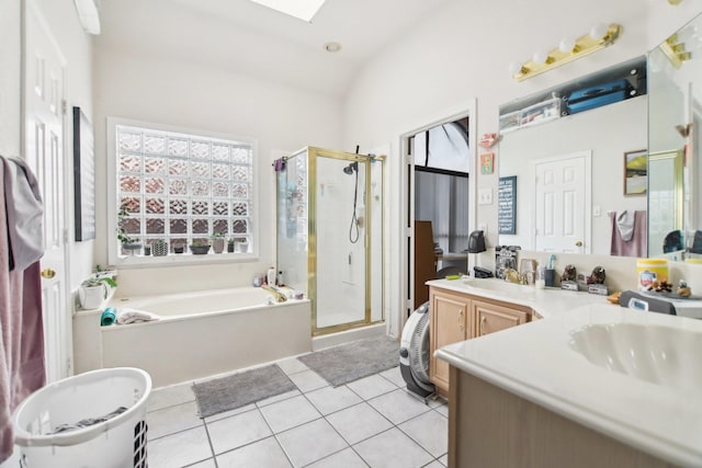 bathroom with tile patterned flooring, a garden tub, a sink, a stall shower, and lofted ceiling with skylight