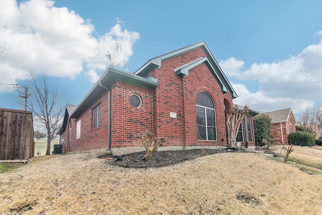 view of home's exterior with brick siding and central AC