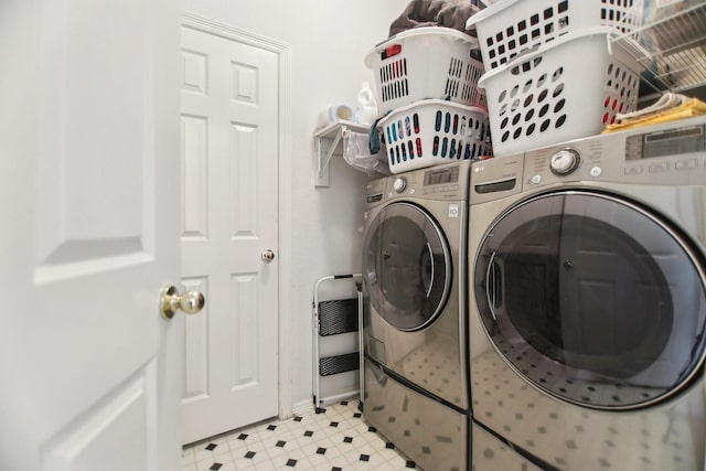 washroom with laundry area, washing machine and dryer, baseboards, and light floors