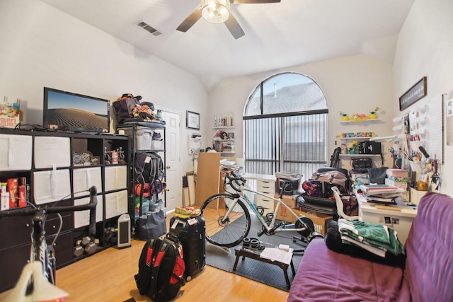 interior space featuring lofted ceiling, wood finished floors, visible vents, and a ceiling fan