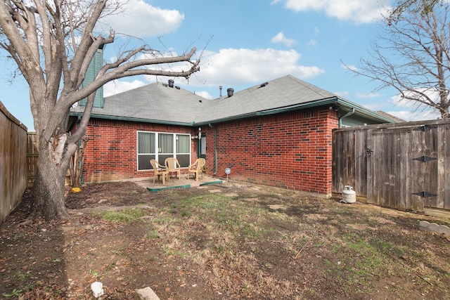 back of house featuring a patio area, brick siding, and a fenced backyard