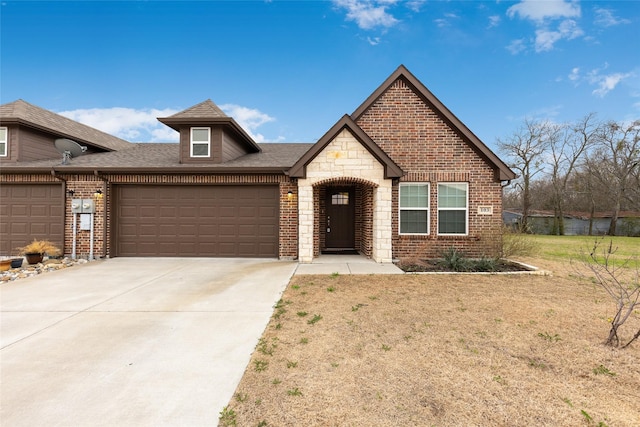 view of front of property with stone siding, brick siding, driveway, and an attached garage