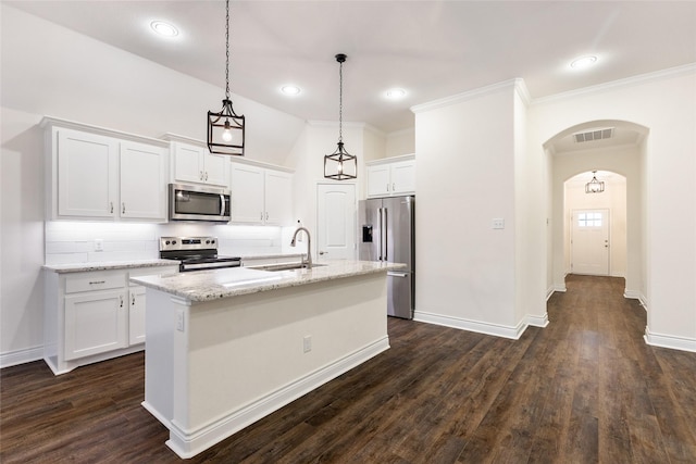 kitchen featuring visible vents, arched walkways, stainless steel appliances, white cabinetry, and a sink