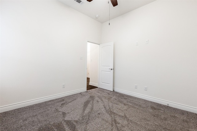 spare room featuring carpet, baseboards, and a ceiling fan