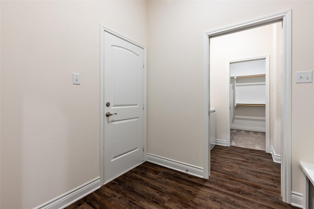 hall featuring dark wood-style floors and baseboards