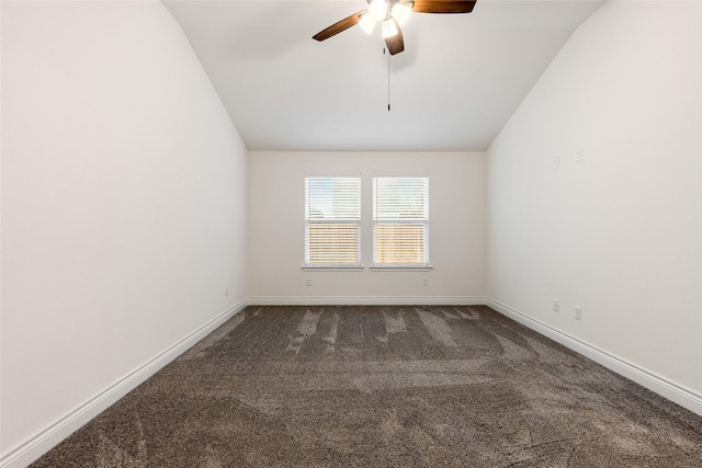 unfurnished room featuring baseboards, dark carpet, vaulted ceiling, and a ceiling fan