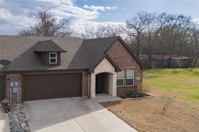 french country inspired facade featuring a garage, concrete driveway, stone siding, a front lawn, and brick siding