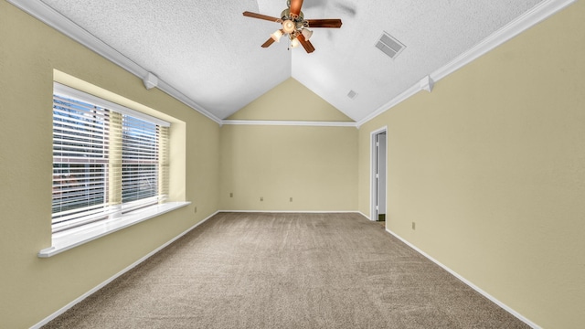 carpeted spare room with ornamental molding, lofted ceiling, visible vents, and baseboards