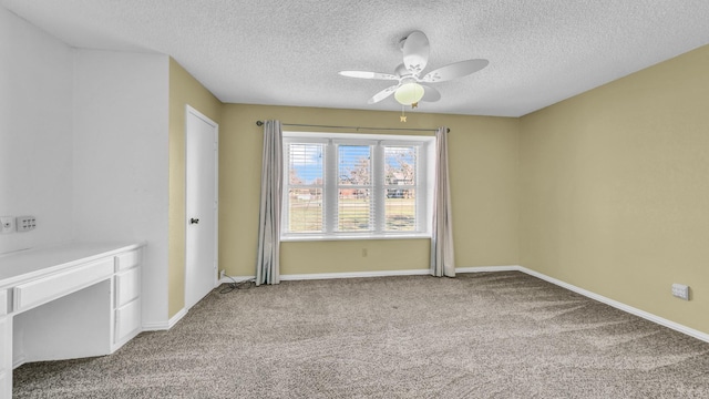 carpeted empty room featuring ceiling fan, baseboards, and a textured ceiling