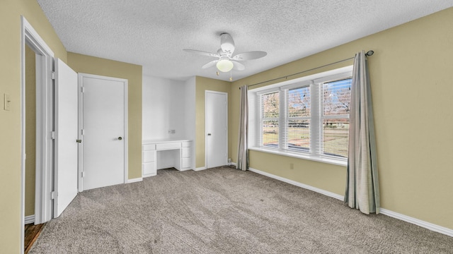 unfurnished bedroom featuring a ceiling fan, carpet, built in study area, and baseboards