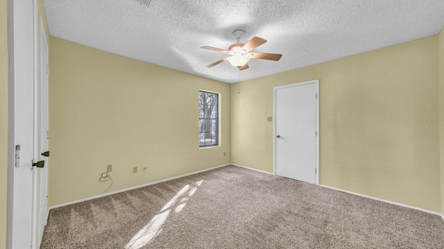 carpeted empty room featuring ceiling fan and a textured ceiling