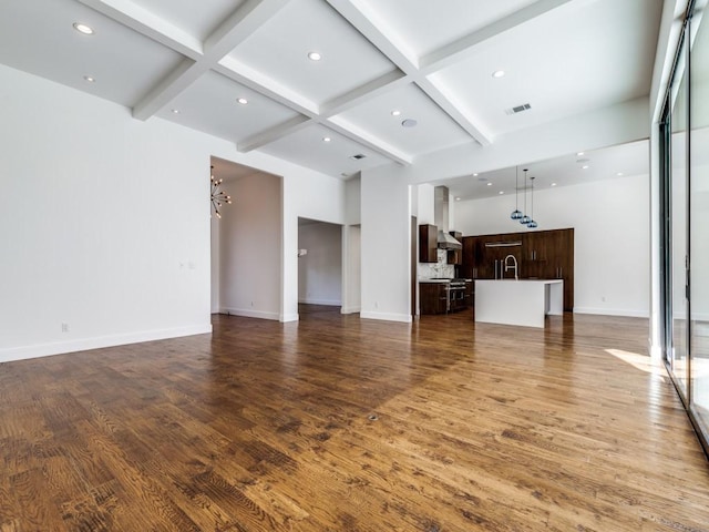 living room with beam ceiling, visible vents, and wood finished floors