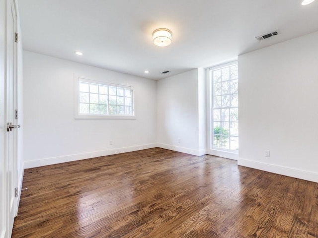 spare room with recessed lighting, visible vents, baseboards, and dark wood-style flooring