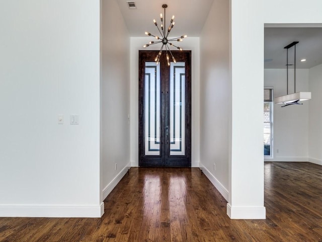 entrance foyer with french doors, baseboards, a chandelier, and dark wood finished floors