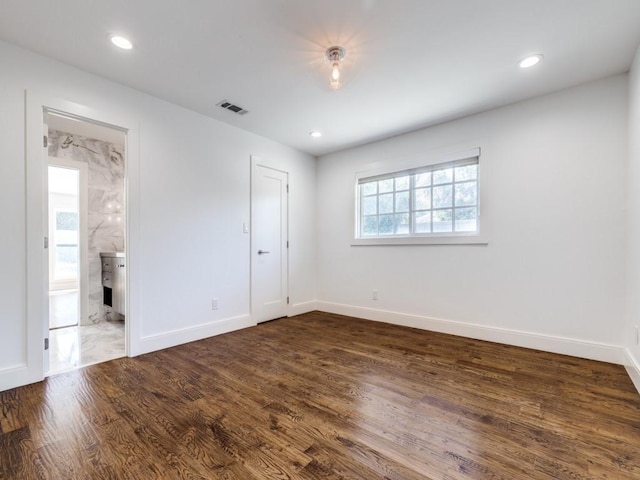 spare room with dark wood-type flooring, recessed lighting, visible vents, and baseboards