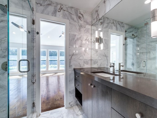 bathroom with vanity, tile walls, marble finish floor, and a shower stall