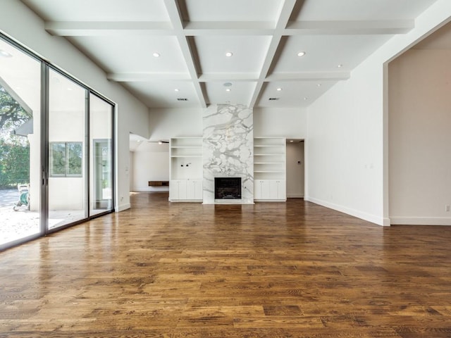 unfurnished living room with beam ceiling, wood finished floors, baseboards, and coffered ceiling