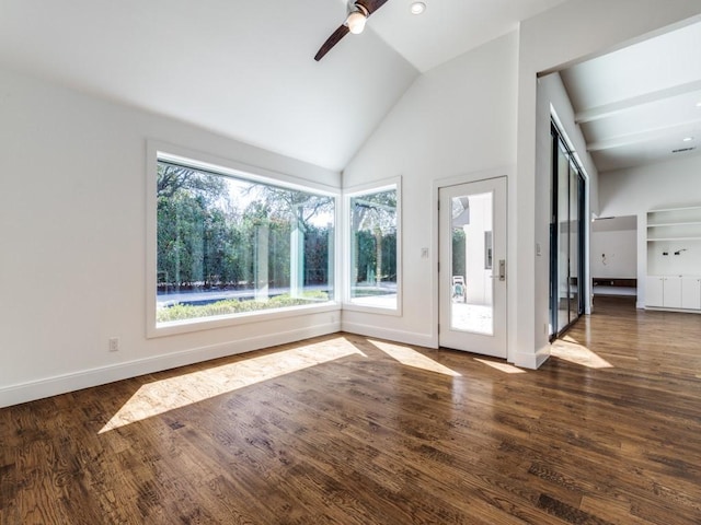 interior space with baseboards, lofted ceiling, wood finished floors, and a ceiling fan