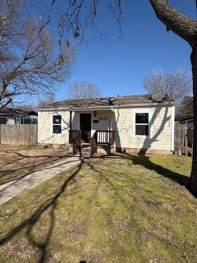 view of front of property featuring fence and a front lawn