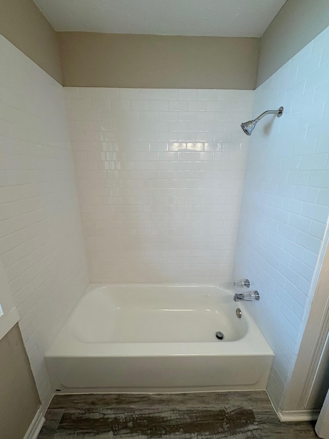 bathroom with shower / washtub combination and wood finished floors