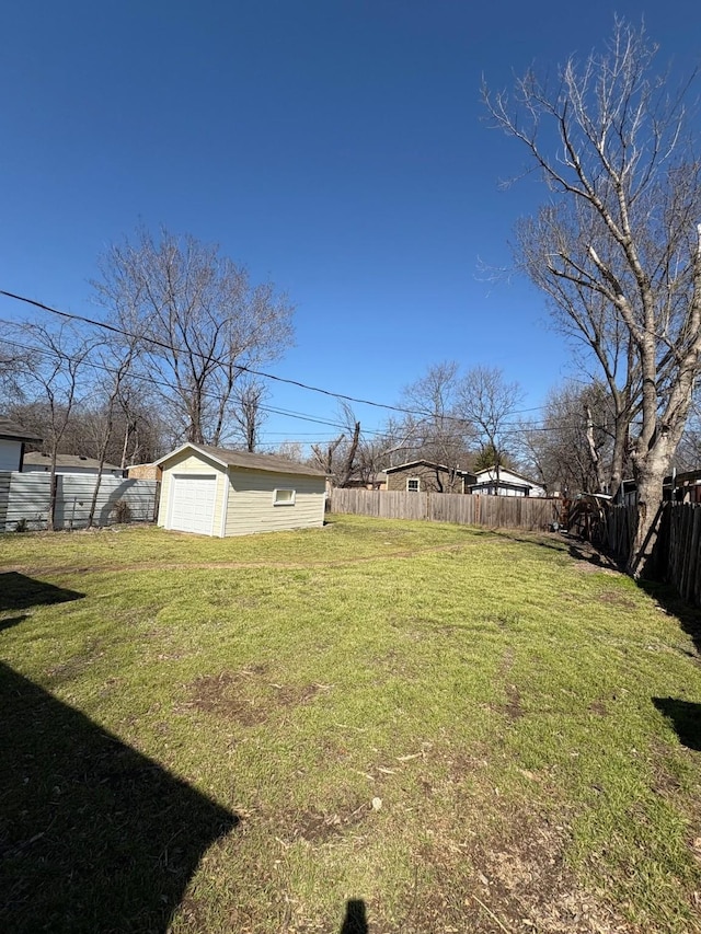 view of yard featuring an outbuilding, a detached garage, and a fenced backyard