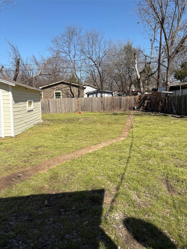 view of yard featuring an outdoor structure and fence