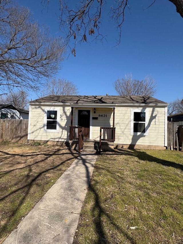 view of front facade with a front lawn, fence, and a porch